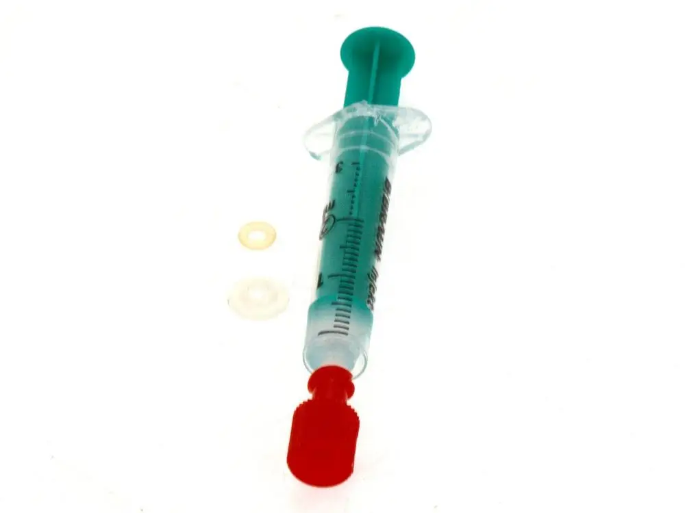 Bosch Dichtungssatz bestehend aus einer klaren Spritze mit rotem Kolben und zwei Dichtungen in verschiedenen Farben, auf hellem Hintergrund abgebildet.